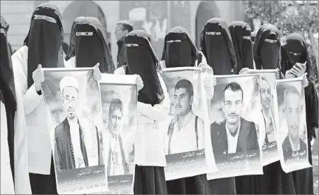  ?? Yahya Arhab European Pressphoto Agency ?? UNIVERSITY STUDENTS take part in an anti-terrorism rally in Sana, Yemen, holding portraits of some of those who died in suicide attacks on two mosques. The attacks last week killed at least 137 men, women and children. Islamic State claimed...