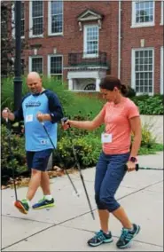  ?? MICHILEA PATTERSON — DIGITAL FIRST MEDIA ?? Lucie Bergeyova, on the right, teaches a man the technique for Nordic Walking during a seminar at the Pottstown Middle School.