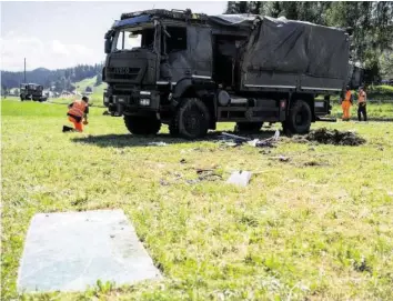  ?? KEYSTONE ?? Ermittler untersuche­n den verunfallt­en Armeelastw­agen: 19 Armeeangeh­örige wurden verletzt.