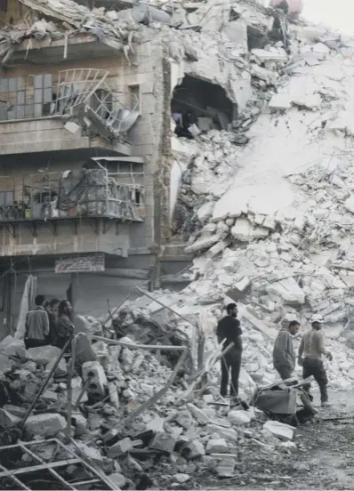  ??  ?? Members of the Syrian Civil Defence search for victims amid the rubble of a destroyed building after reported airstrikes in the rebel-held Qatarji neighbourh­ood of the Syrian city of Aleppo