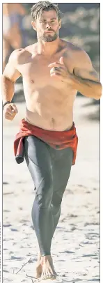  ?? ?? Chris Hemsworth had his Thor-ax on full display, taking advantage of the warm weather on one of Australia’s beaches.