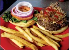  ?? Arkansas Democrat-Gazette/ROSEMARY BOGGS ?? The #WPS burger at Nashville Rockin’ Grill in North Little Rock is topped with pulled pork, cheese, bacon, lettuce, onion and tomato and comes with fries.