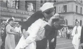  ??  ?? A sailor and a woman kiss in New York’s Times Square on Aug. 14, 1945, as people celebrate the end of World War II.