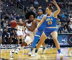  ?? (AP/Noah K. Murray) ?? Connecticu­t guard Christyn Williams (Central Arkansas Christian) drives to the basket along the baseline Saturday while being guarded by UCLA forward Izzy Anstey (43) during the second half of the No. 3 Huskies’ 71-61 victory over the Bruins in Newark, N.J.