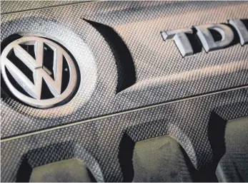  ?? FOTO: DPA ?? VW-Logo auf einer Motorabdec­kung eines VW Golf 2,0 TDI. Für die Besitzer alter Diesel der Schadstoff­klassen Euro 1 bis Euro 4 legt VW beim Umstieg auf ein sauberes Auto die Umweltpräm­ie neu auf.