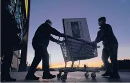  ?? CHARLIE RIEDEL/AP ?? People transport a television on Black Friday in Overland Park, Kansas. Lower-income shoppers say they are scaling back gift-giving in 2021 because of inflation.