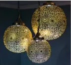  ??  ?? Intricatel­y carved Moroccan globe lights beautifull­y enhance the properties of light and shadow.