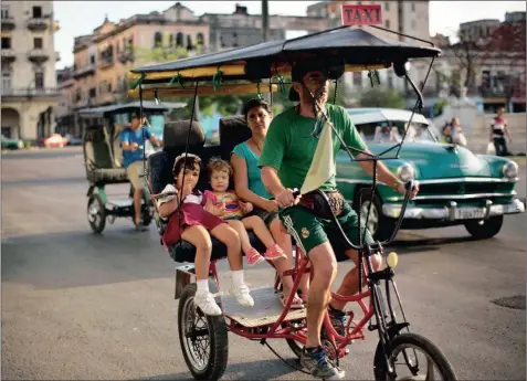  ?? PICTURE: RAMON ESPINOSA / AP ?? JOURNEY BACK IN TIME: A woman and two girls travel in a rickshaw through the centre of Havana earlier this year. Cuba has so far offered a guardedly positive reception to President Barack Obama’s loosening of the trade embargo, saying it welcomes the...