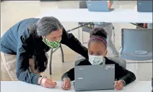  ?? MATT STONE / BOSTON HERALD ?? Yaline Cardoso-Barreto 8, gets help from Maggie Mattaini, program administra­tor for the YMCA, on her school work at the YMCA on Sept. 21 in Roxbury. A recent Pioneer Institute poll showed many parents have been disappoint­ed in the level of education their kids received during the pandemic.