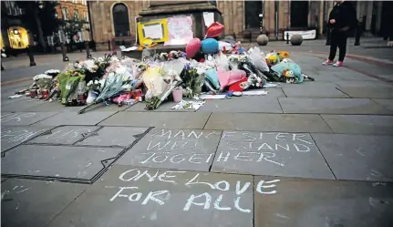  ?? / STEFAN WERMUTH / REUTERS ?? A woman pays her respects after laying flowers for the victims of Monday night’s Manchester Arena attack in central Manchester on Tuesday.