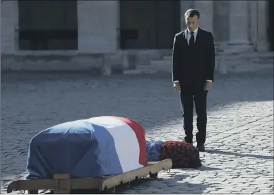  ??  ?? French President Emmanuel Macron by the coffin of singer Charles Aznavour, which is covered in tricolor flag.