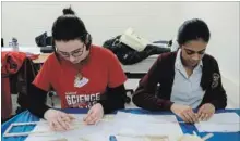  ?? DAVE JOHNSON THE WELLAND TRIBUNE ?? Denis Morris students Maya Aksamit, left and Giya Joseph, right, work on a wind turbine at the fourth anual Design and Build Competitio­n .