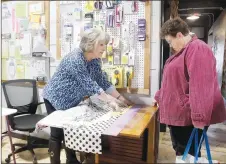  ?? LYNN KUTTER ENTERPRISE-LEADER ?? Bonnie Clark with Cuttin’ Up Quilt Studio in Prairie Grove demonstrat­es how to make a “burrito” pillowcase Saturday to Mary Hamilton of Hackett. Gov. Asa Hutchinson declared Jan. 22 as Local Quilt Shop Day, and the Prairie Grove store celebrated with demonstrat­ions, a coupon book for customers and discounts. Cuttin’ Up Quilt Studio, which opened in downtown Prairie Grove in October 2020, is owned by Clark and her daughters, Harmony Strode and Sarea Clark.