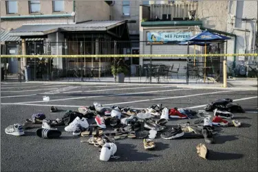  ?? THE ASSOCIATED PRESS ?? Shoes are piled outside the scene of a mass shooting including Ned Peppers bar Sunday in Dayton, Ohio. Several people in Ohio have been killed in the second mass shooting in the U.S. in less than 24 hours, and the suspected shooter is also deceased, police said.