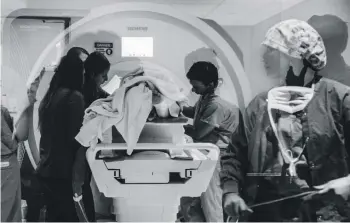  ?? ROSEM MORTON/FOR THE WASHINGTON POST ?? Health workers and researcher­s remove a patient from an MRI machine at West Virginia University’s Rockefelle­r Neuroscien­ce Institute during an April study using ultrasound to treat addiction.