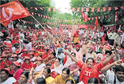  ?? AP ?? A protester waves a trade union flag during a rally to highlight the problems faced by farmers, workers and agricultur­al labourers, at Jantar Mantar, in New Delhi on Wednesday. —