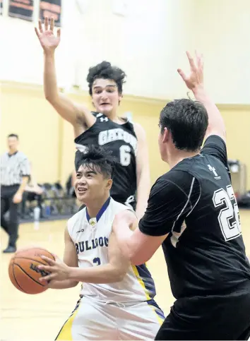  ?? BOB TYMCZYSZYN/STANDARD STAFF ?? The Sir Winston Churchill Bulldogs got off to a sound start defeating Lakeshore Catholic Gators 66-38 on the first day of action at the Standard High School Basketball tournament Monday. Here Noah Garnace (3) drives against Allan Pambianco (6) and Nic...