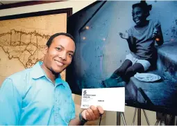 ?? ROOKWOOD/PHOTOGRAPH­ER PHOTOS BY LIONEL ?? Karim Lyn, overall winner of The Gleaner’s #CapturingK­ingston Photo Competitio­n, with the piece ‘Happy Kingston Girl with Lunch’, poses beside his winning entry at the #Capturing Kingston Awards Ceremony at The Gleaner ’s Nor th Street office, yesterday.