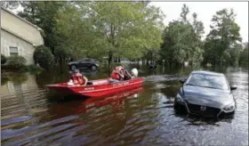  ?? GERRY BROOME — THE ASSOCIATED PRESS ?? Members of the U.S. Coast Guard Shallow Water Rescue Team check on a flooded neighborho­od in Lumberton, N.C., Monday in the aftermath of Hurricane Florence.