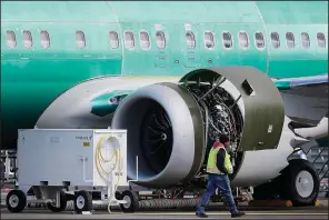  ?? AP/TED S. WARREN ?? A worker walks past an engine of a Boeing 737 Max 8 airplane being built for American Airlines at Boeing Co.’s assembly plant in Renton, Wash., last week.