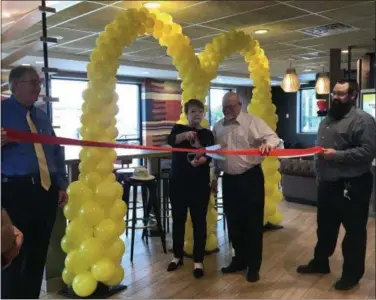  ?? GINGER RAE DUNBAR - DIGITAL FIRST MEDIA ?? Laura Sander, owner/operator of the McDonald’s in Downingtow­n, assisted by Downingtow­n Borough Manager Steve Sullins, cuts the ribbon during the grand reopening celebratio­n on Monday.