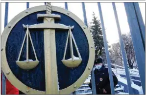  ?? (AP/Alexander Zemlianich­enko) ?? A police officer on Wednesday guards an entrance to the Moscow City Court as supporters of the Memorial Human Rights Center gather to protest the ruling shutting down the prominent organizati­on under a “foreign agents” law.