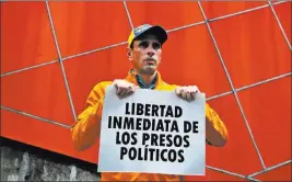  ?? Fernando Llano ?? The Associated Press Opposition leader Henrique Capriles holds a poster Monday that reads “Freedom immediatel­y for political prisoners” after a meeting at which opposition decided to plan a symbolic referendum to give voters the opportunit­y to reject...