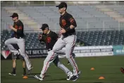  ?? ROSS D. FRANKLIN — THE ASSOCIATED PRESS ?? Giants catcher Buster Posey, right, jumps in the air as he warms up with teammates during spring training workouts on Wednesday in Scottsdale, Ariz.