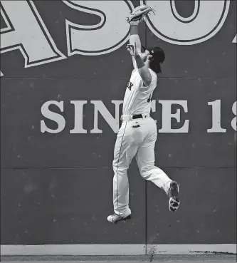  ?? CHARLES KRUPA/AP PHOTO ?? Boston left fielder Andrew Benintendi leaps and makes the play on fly out by St. Louis’ Jose Martinez during the third inning of Tuesday’s game at Fenway Park. Boston won, 10-4.