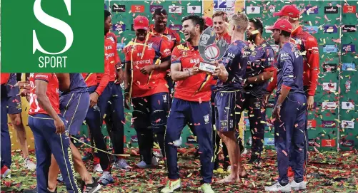  ?? MUZI NTOMBELA BackpagePi­x ?? LIONS players celebrate with the trophy after beating the Dolphins in the T20 Challenge final in Durban yesterday. |