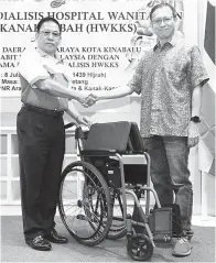  ??  ?? ASNAN (kiri) menyampaik­an kerusi roda kepada wakil unit hemodialis­is.