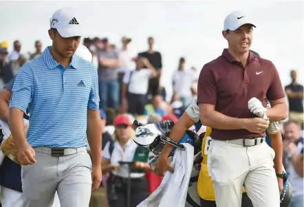  ??  ?? Friend and foe: Northern Ireland’s Rory McIlroy (right) and US golfer Xander Schauffele leave the ninth tee during the third round of the British Open at Carnoustie in Scotland on Saturday. — AFP