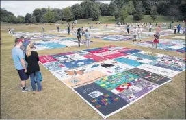  ?? STEVE SCHAEFER PHOTOS / SPECIAL TO THE AJC ?? People walk around the AIDS Memorial Quilt at Piedmont Park. The quilt was created as a memorial to those who have died of AIDS.