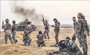  ??  ?? Turkish soldiers and Syrian fighters gather on the northern outskirts of the Syrian city of Manbij near the Turkish border on Tuesday.
AFP