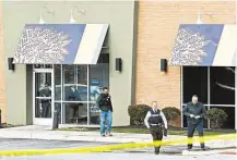  ?? Patrick Semansky / Associated Press ?? Investigat­ors seek evidence Wednesday outside a shopping center restaurant in Abingdon, Md., where a sheriff’s deputy was shot to death. Another deputy was slain nearby.