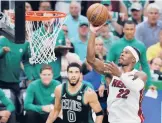  ?? MICHAEL DWYER/AP ?? The Heat’s Jimmy Butler goes up for a shot against the Celtics’ Jayson Tatum on Friday night.