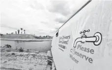  ?? CHRIS CARLSON, AP ?? A sign urges water conservati­on in front of recycled wastewater in a holding pond in Anaheim, Calif.