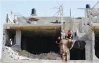  ?? (Ibraheem Abu Mustafa/Reuters) ?? PALESTINIA­NS WORK on a house in Khan Yunis yesterday that was destroyed by Israeli airstrikes during fighting in May.