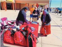  ?? COURTESY OF NAVAJO HOPI FAMILIES COVID-19 RELIEF FUND ?? Shandiin Herrera with the Navajo Hopi Families COVID-19 Relief Fund distribute­s masks, hand sanitizer and wipes at a grocery store in Kayenta, Arizona, on the Navajo Nation.