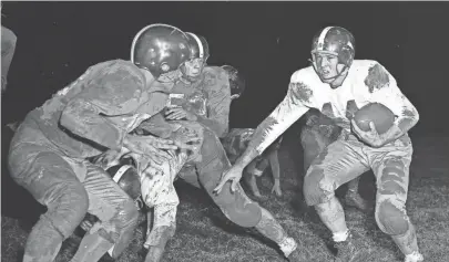  ??  ?? South Side’s Marvin Throneberr­y, right, is cornered by Catholic High’s John Burnette, but not until after Thorneberr­y had ripped off a sizable gain that set up his 21-yard touchdown run. The Scrappers won 32-7 on 14 Nov 1951. CHARLES NICHOLAS/THE COMMERCIAL APPEAL