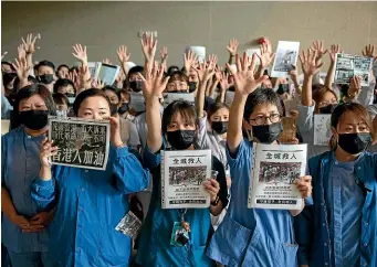  ?? GETTY IMAGES ?? Doctors and nurses hold their hands up as they sing the Hong Kong protest anthem during a pro-democracy demonstrat­ion at Prince of Wales Hospital in Hong Kong. Pro-democracy protesters have continued demonstrat­ions across the city.