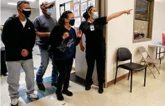  ??  ?? Melissa Lara, right, directs people to waiting stations to receive their COVID-19 vaccinatio­ns at the center.