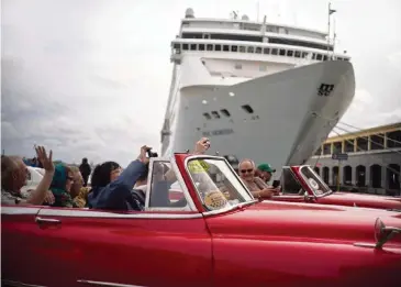  ?? RAMON ESPINOSA AP file, 2018 ?? Tourists tour Havana as they drive in front of a cruise ship. Cruise Lines Internatio­nal Associatio­n, the industry’s lobbying group, estimates the U.S. decision to ban Cuba cruises will affect 800,000 passengers who have already booked.