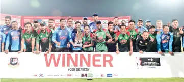  ?? - AFP photo ?? Bangladesh­i cricketers pose with the tournament trophy following the third one-day internatio­nal (ODI) between Bangladesh and West Indies at the Sylhet Internatio­nal Cricket Stadium in Sylhet.