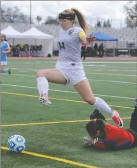  ?? BEA AHBECK/NEWS-SENTINEL ?? Libery Ranch's McKenna Brown leaps over Center's goalie Jenna Tardiff during their SacJoaquin Section Division IV championsh­ip game in Elk Grove on March 3.