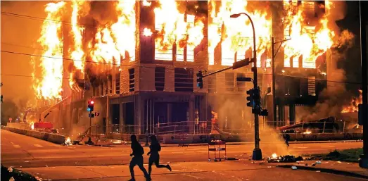  ??  ?? Minneapoli­s burning: Whole blocks of the city are destroyed by fire, causing damage estimated at £397 million