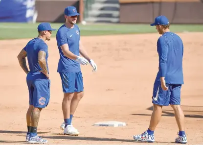  ?? QUINN HARRIS/GETTY IMAGES ?? Cubs stars Javy Baez (from left), Kris Bryant and Anthony Rizzo chat during workouts Friday at Wrigley Field.