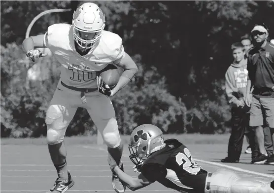  ?? | WORSOM ROBINSON/ FOR THE SUN-TIMES ?? Notre Dame’s Tim Simon (10) escapes Lucas Psoewicz’s tackle attempt Saturday. Simon caught four passes for 119 yards and two touchdowns.