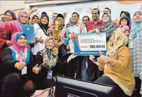  ?? PIC BY RASUL AZLI SAMAD ?? Health Minister Datuk Seri Dr S. Subramania­n (centre) presenting a mock cheque for RM2,500 to the winners, from Perlis, of an oral competitio­n held during the 8th Health Clinic Advisory Panel National Convention in Malacca yesterday.