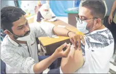  ??  ?? A health worker incoluates a man with a dose of the Sinopharm Covid-19 coronaviru­s vaccine at a vaccinatio­n centre in Karachi. — AFP file photo